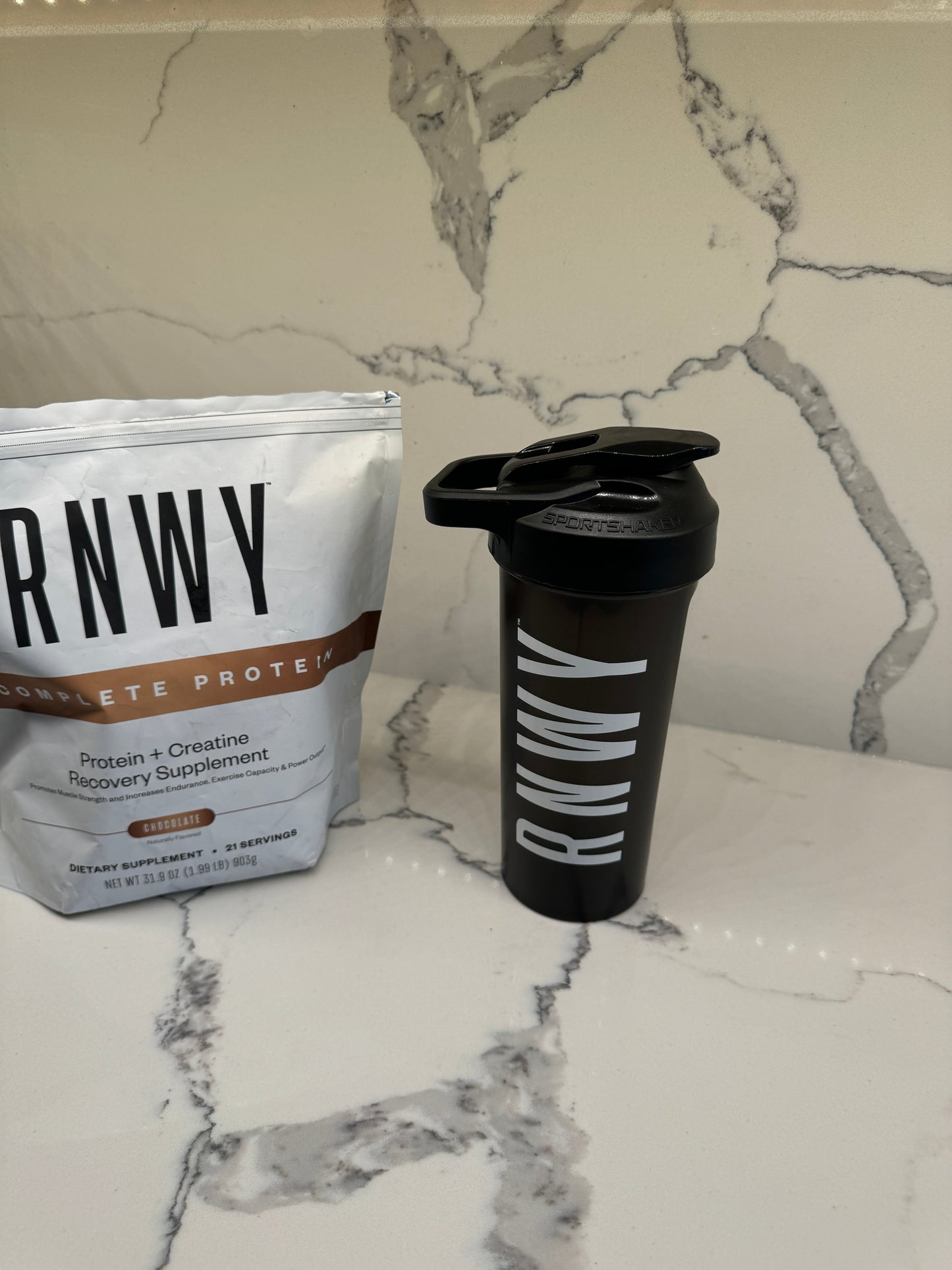 RWNW protein powder package and shaker bottle on a marble surface