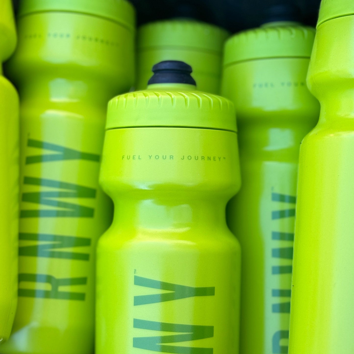 Stack of yellow water bottles with 'RWY' branding.