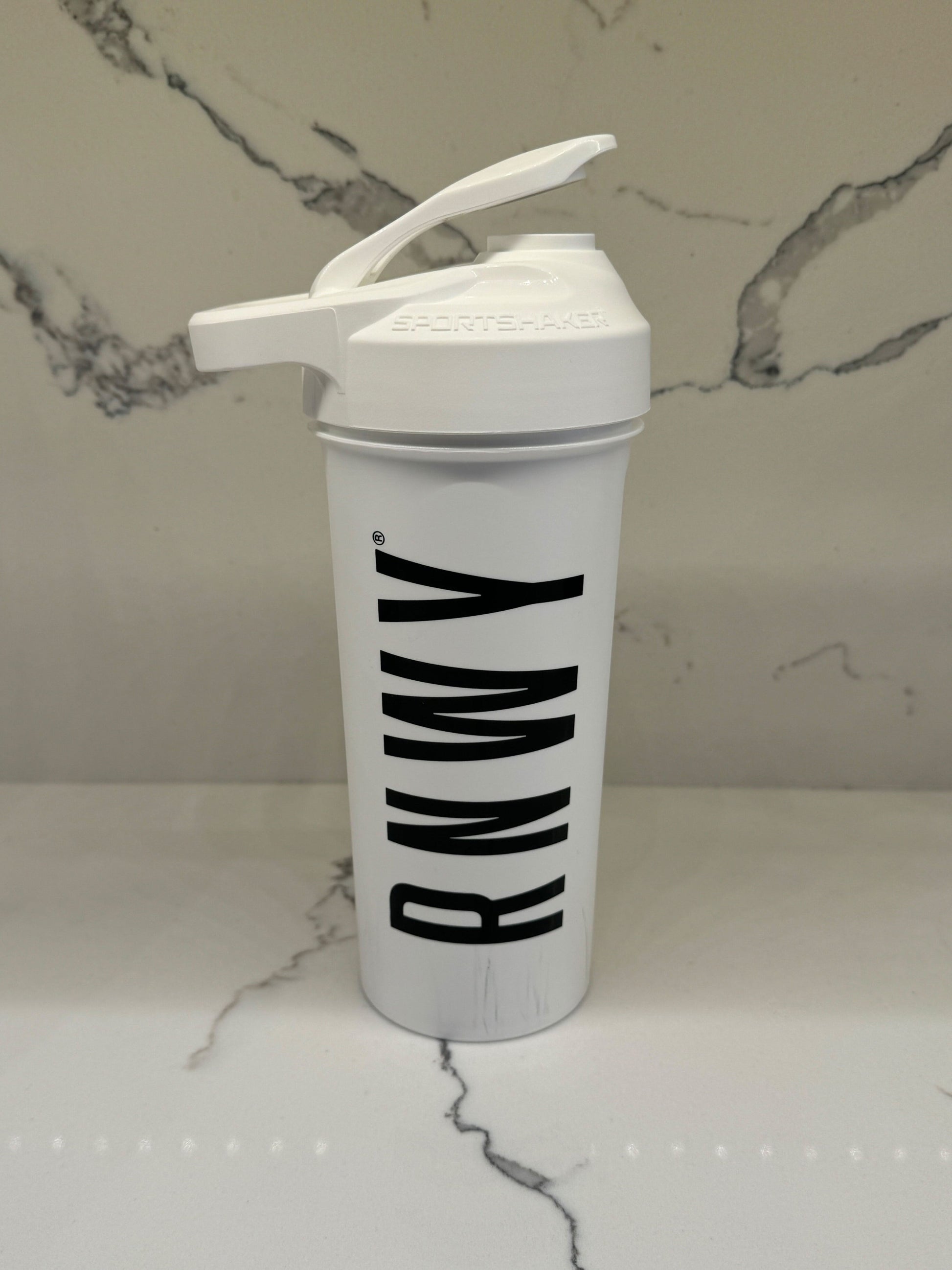White shaker bottle with 'Ramy' branding on a marble surface
